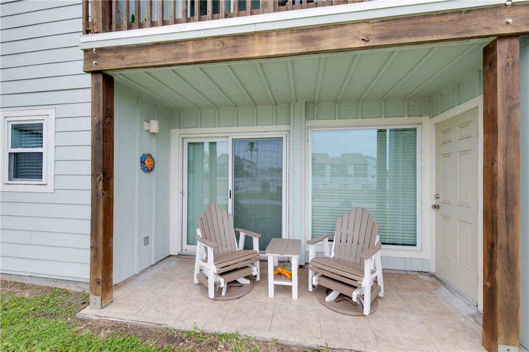 230 Cut-Off Road, Unit 101 Port Aransas, TX 78373 - Photo 23 of 30 a view of backyard with a chair and table in front of house