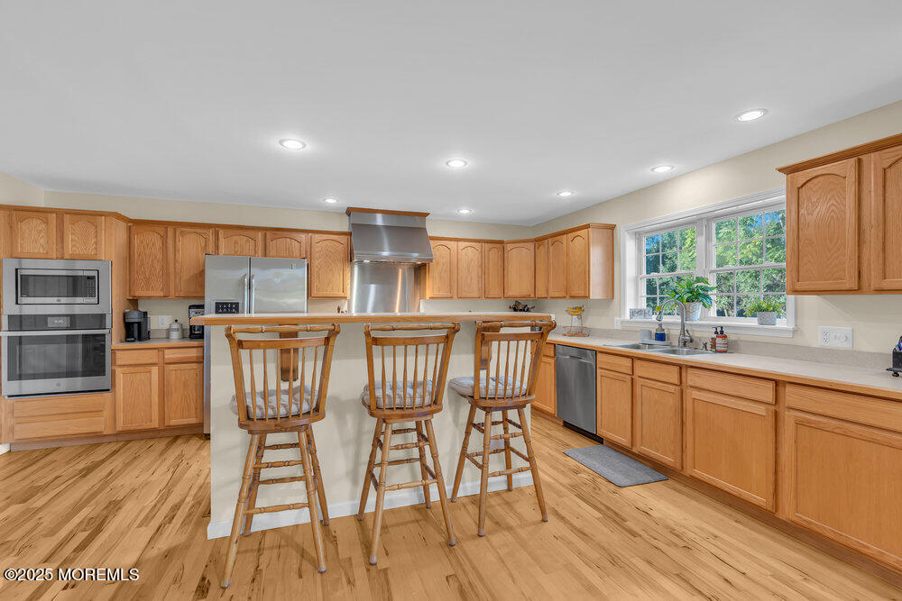 87 Maple Avenue Tuckerton, NJ 08087 - Photo 15 of 48 a kitchen with stainless steel appliances granite countertop a kitchen island hardwood floor sink stove dining table and chairs