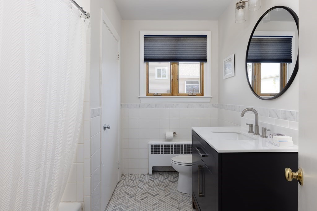 66 Roosevelt Road Newton, MA 02459 - Photo 13 of 17 a bathroom with a sink a mirror and a window