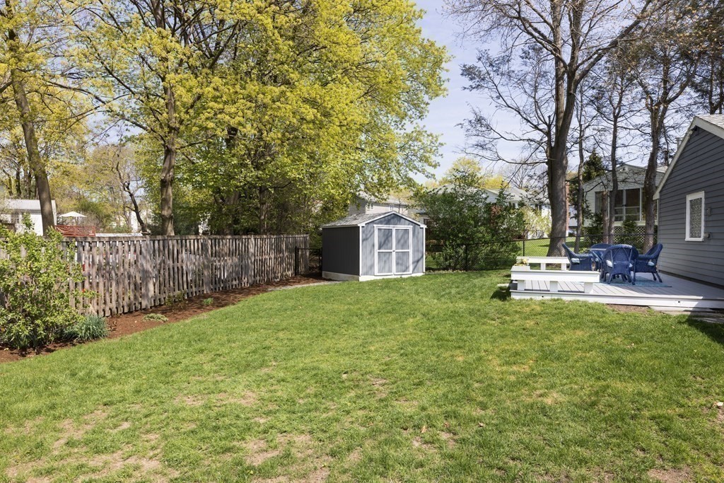 66 Roosevelt Road Newton, MA 02459 - Photo 16 of 17 a view of a back yard with a table and chair and wooden fence