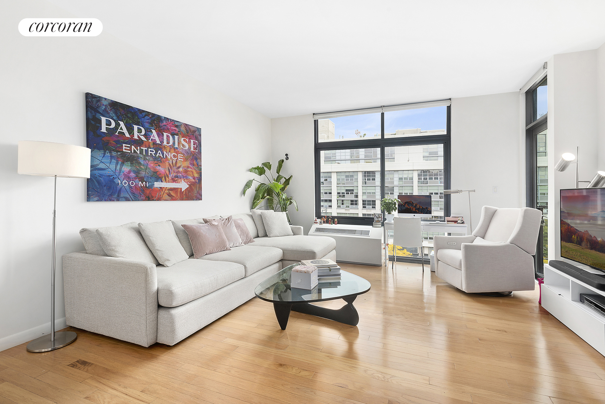 48-21 5th Street, Unit 5C Queens, NY 11101 - Photo 1 of 1 a living room with furniture and a large window
