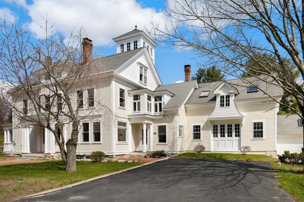 a front view of a white house with a yard