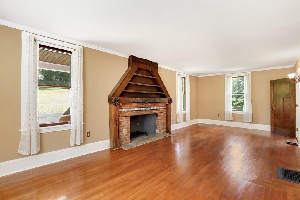 324 Turnpike Road Ashby, MA 01431 - Photo 12 of 41 an empty room with wooden floor fireplace and windows