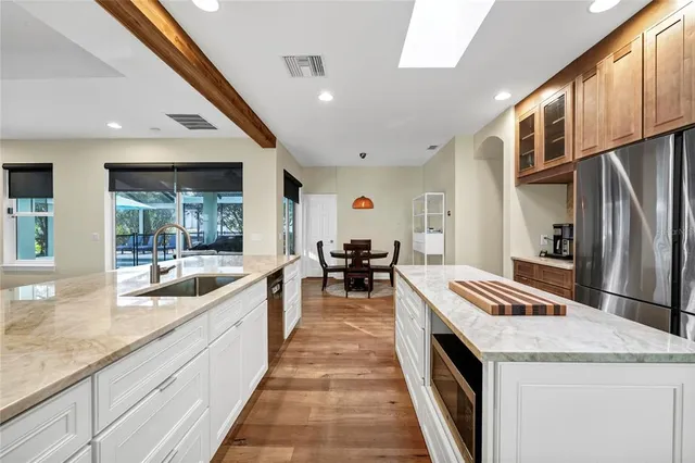 a large kitchen with stainless steel appliances granite countertop a large counter top a stove and a refrigerator