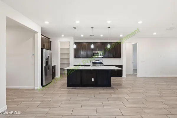 a large kitchen with a large counter top stainless steel appliances and cabinets