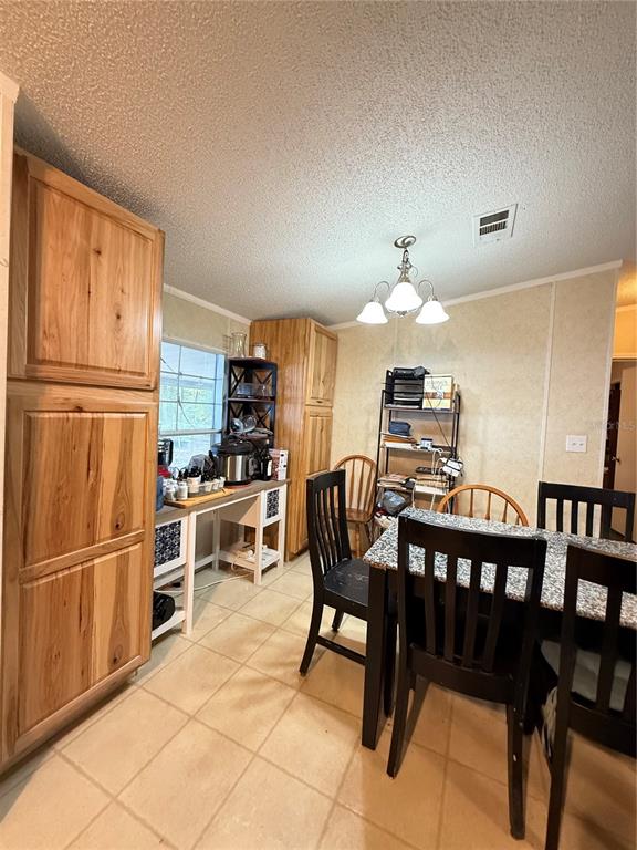 5109 Southwest 10th Street Bell, FL 32619 - Photo 25 of 38 a kitchen with stainless steel appliances granite countertop a stove a refrigerator a dining table and chairs with wooden floor
