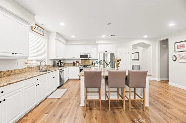 a kitchen with granite countertop white cabinets and stainless steel appliances