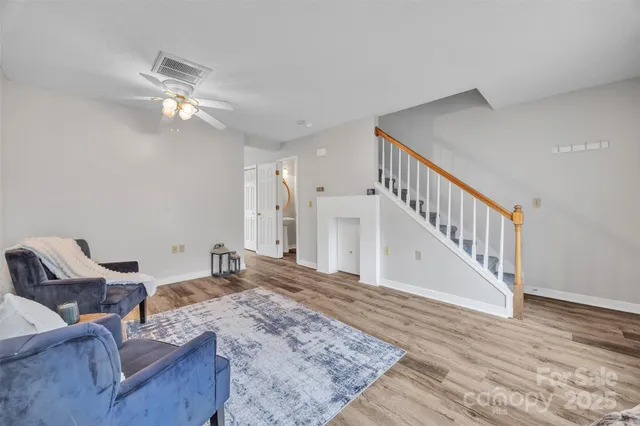 a view of a livingroom with wooden floor and stairs