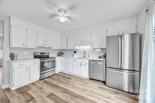 a kitchen with a refrigerator stove and white cabinets