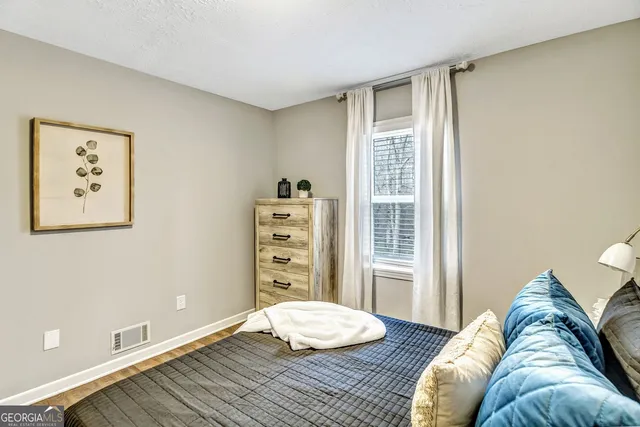 a bedroom with a bed and wooden floor