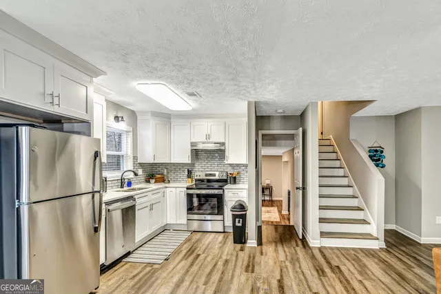 a kitchen with a refrigerator a stove and cabinets
