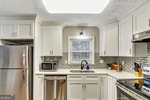 a kitchen with stainless steel appliances a refrigerator a sink a stove a microwave and cabinets