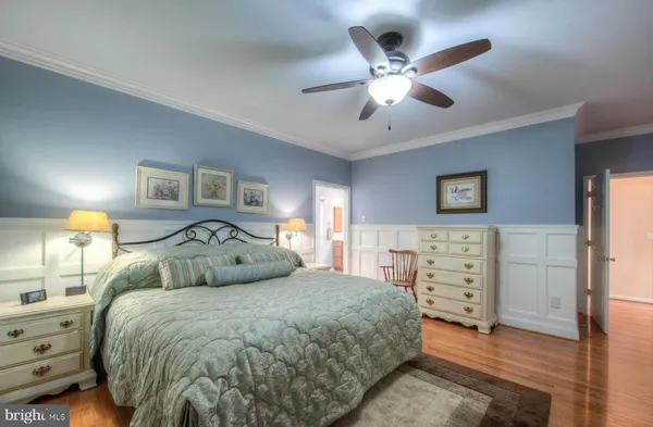 a bedroom with a large bed and a ceiling fan