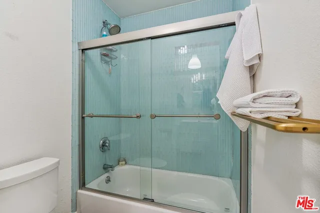 a bathroom with a granite countertop sink a toilet and shower