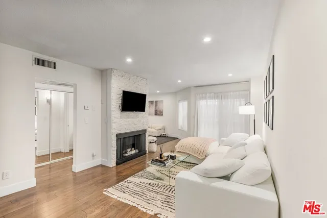 a living room with furniture a flat screen tv and a fireplace