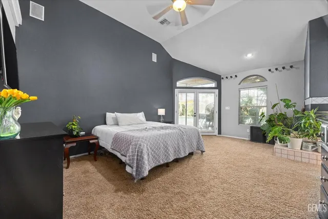 a spacious bedroom with a bed chandelier and window