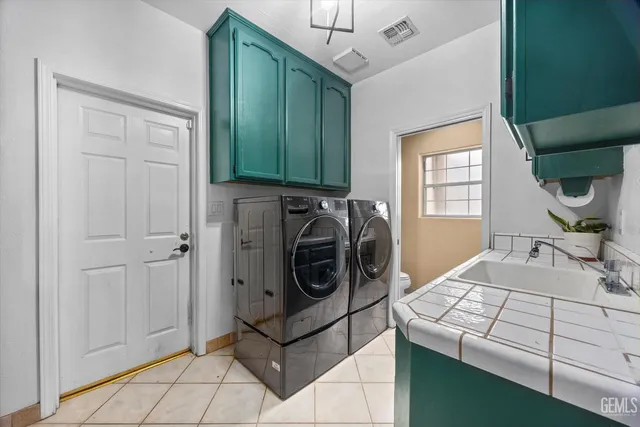 a utility room with cabinets dryer and washer