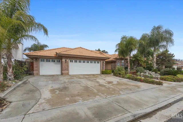a view of a house with a yard and palm trees