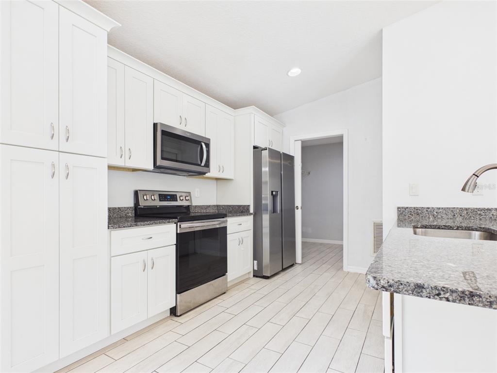 4309 Southwest 143rd Ln Road Ocala, FL 34473 - Photo 8 of 21 a kitchen with stainless steel appliances granite countertop a refrigerator a stove and a sink