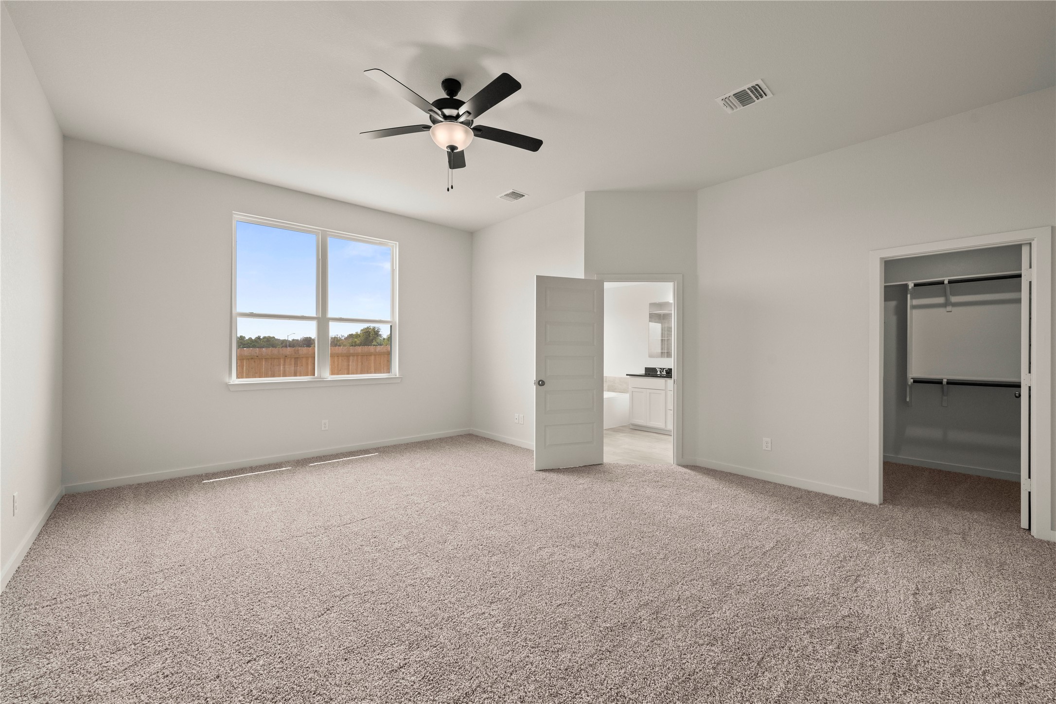 247 Gus Loop Georgetown, TX 78626 - Photo 10 of 17 Plush carpeting and elevated ceilings anchor this light-filled suite with an attached bath.