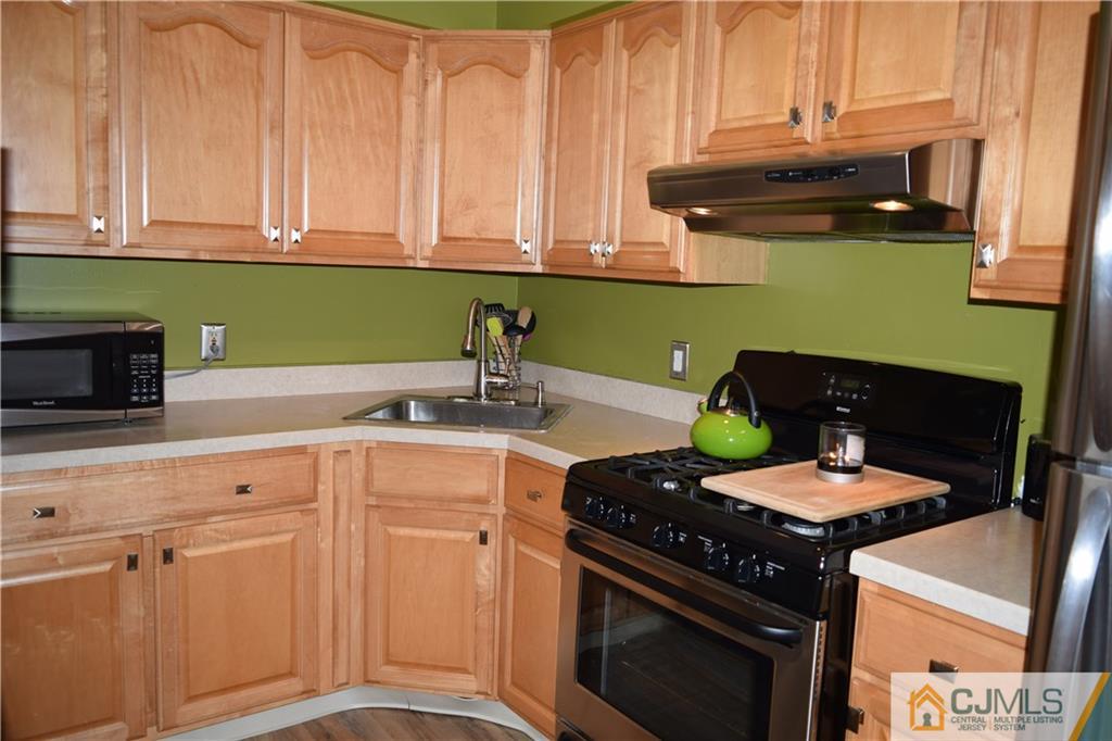 287 Nebula Road, Unit 287 Piscataway, NJ 08854 - Photo 7 of 16 a kitchen with stainless steel appliances granite countertop a stove a sink and a microwave