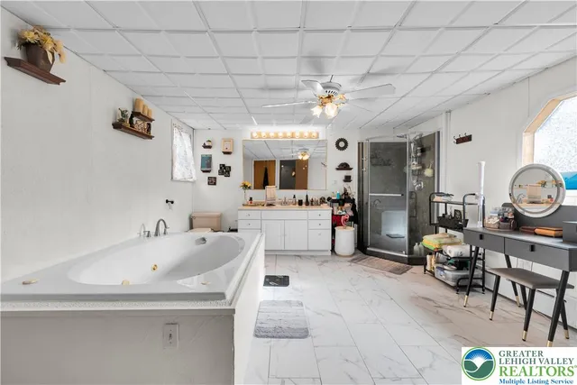 a large white kitchen with a sink a window and chairs