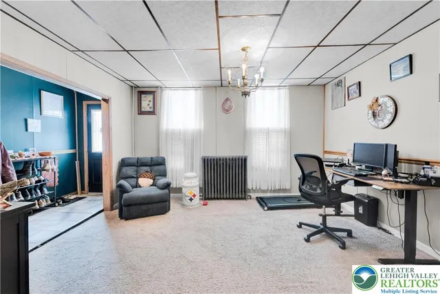 a view of a livingroom with workspace and a window