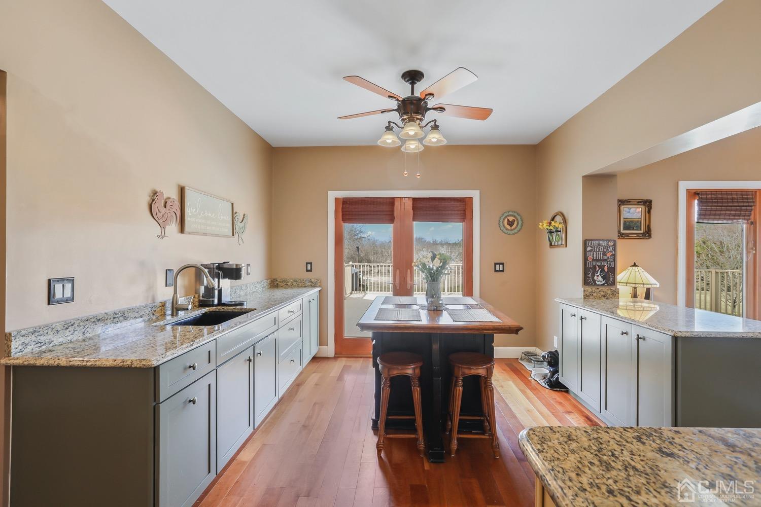 39 Loveman Road Cream Ridge, NJ 08514 - Photo 29 of 73 a kitchen with stainless steel appliances granite countertop a stove a sink dishwasher and a dining table with wooden floor