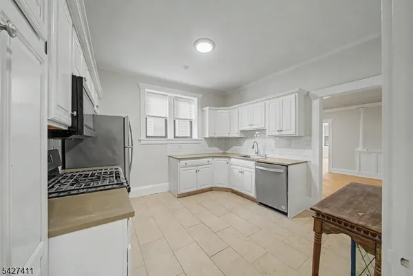 a kitchen with white cabinets and appliances