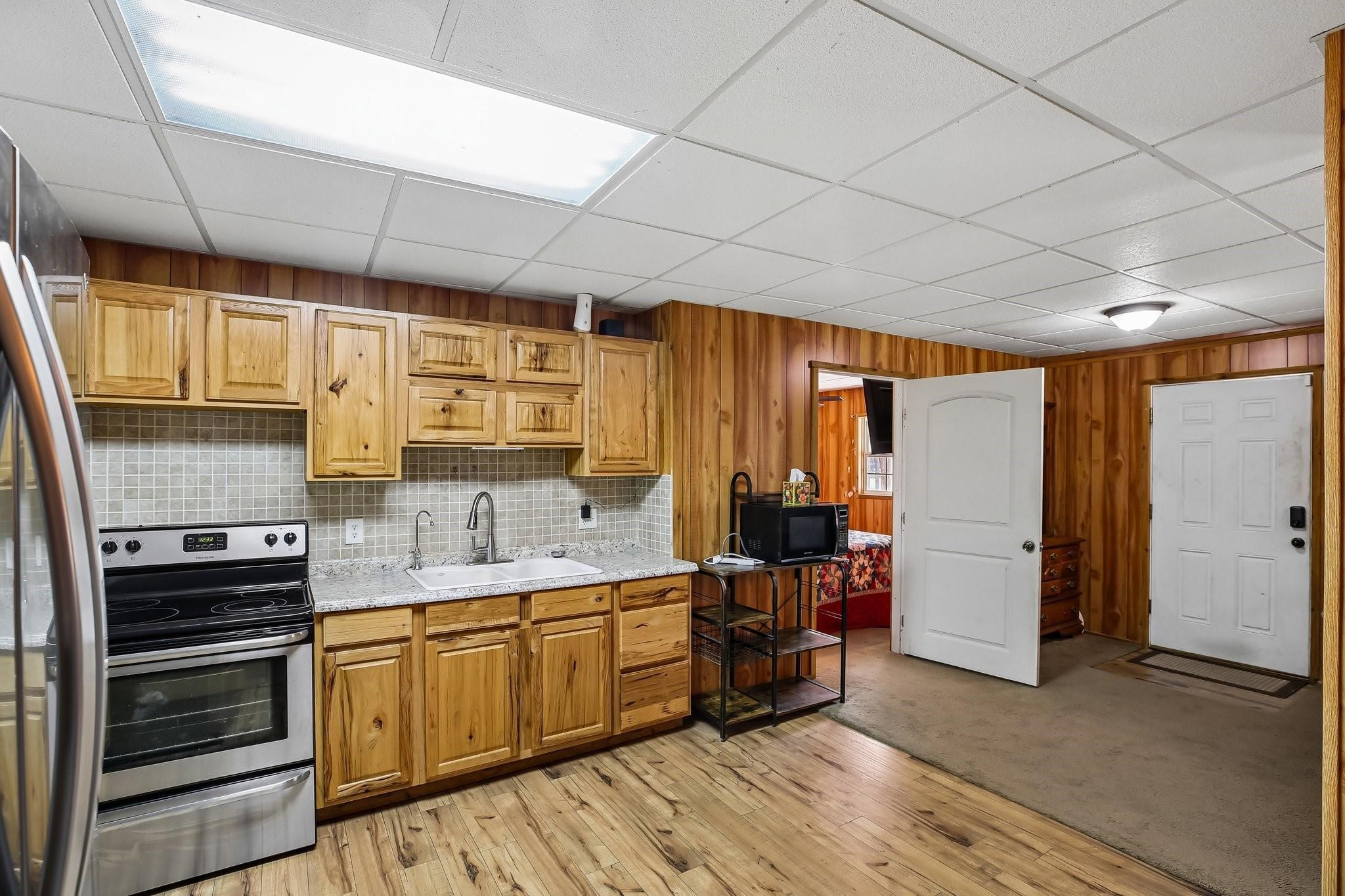 164 Frank Road Trinity, TX 75862 - Photo 16 of 20 16. The kitchen is as functional as it is charming, featuring abundant wood cabinetry and generous counter space for meal prep. The open layout and breakfast bar seating create a perfect transition into the living area, keeping the home feeling connected and spacious.