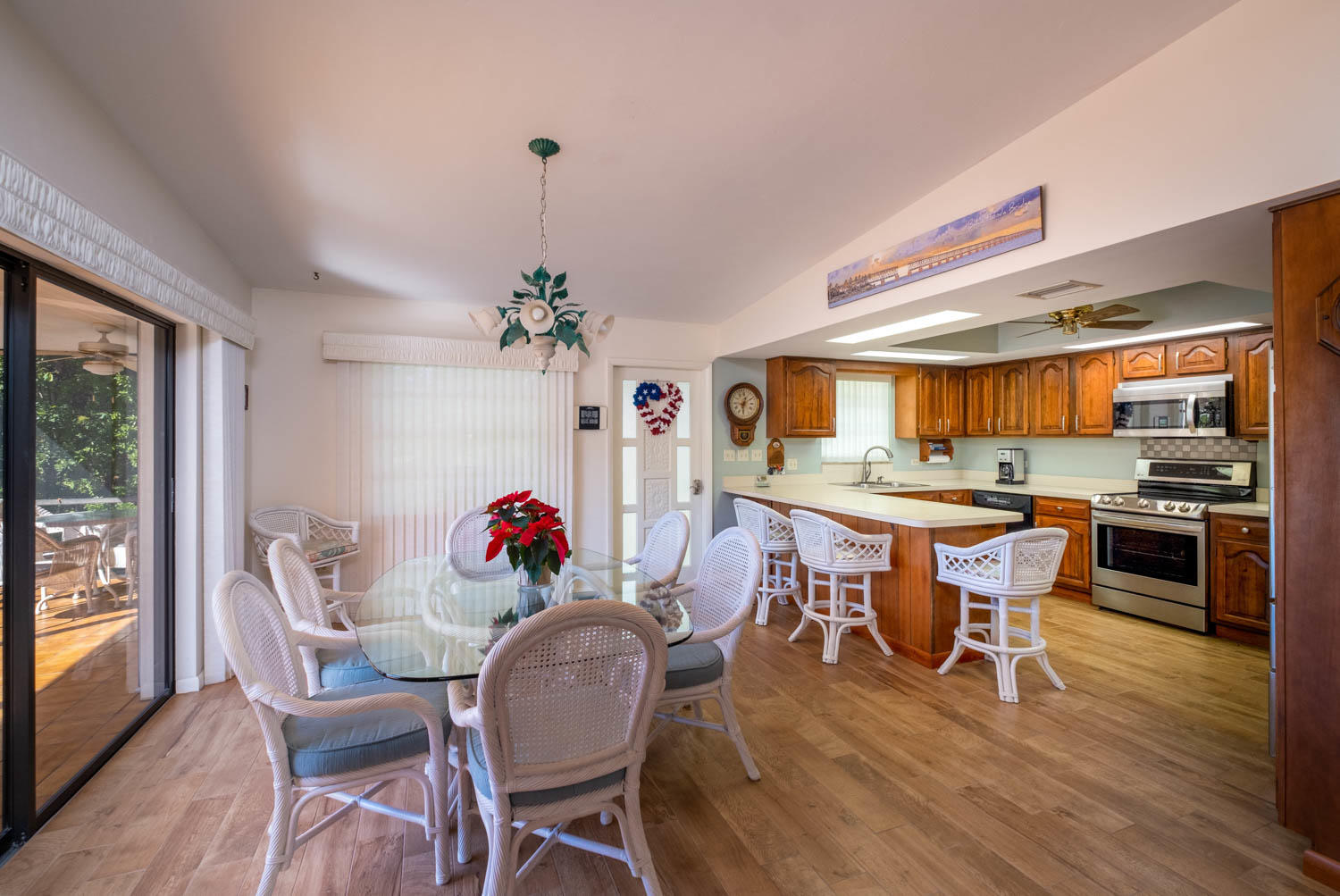 205 Sunset Boulevard Key Largo, FL 33037 - Photo 12 of 42 a dining room with wooden floor a chandelier a wooden table and chairs