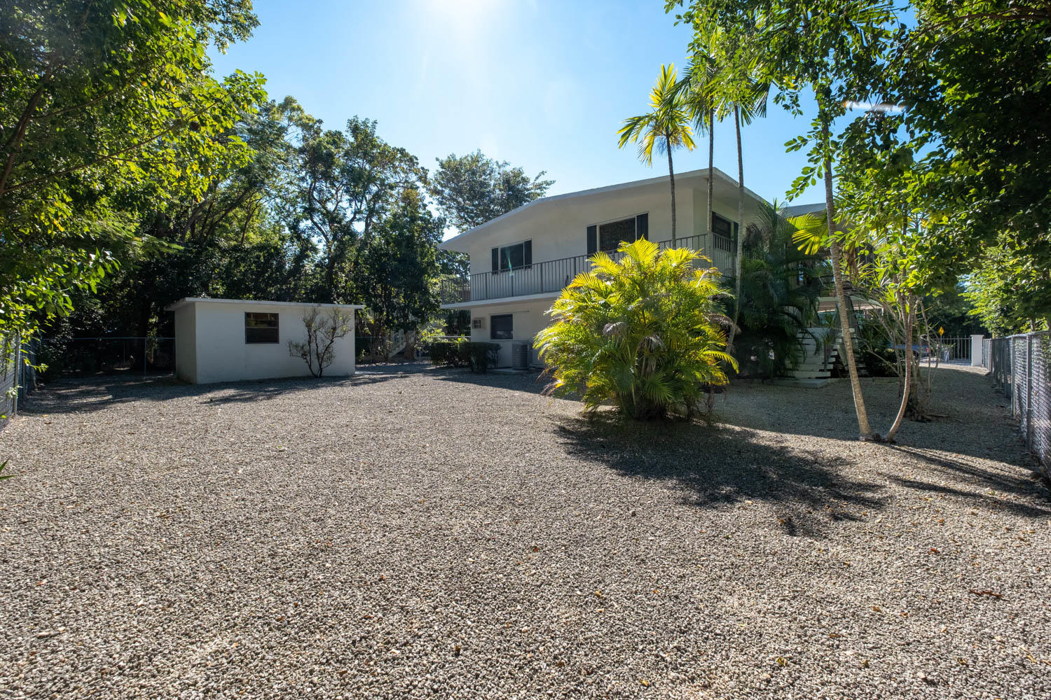205 Sunset Boulevard Key Largo, FL 33037 - Photo 4 of 42 a backyard of a house with potted plants and large trees