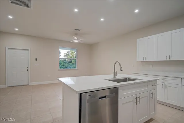 a kitchen with kitchen island white cabinets appliances and a sink
