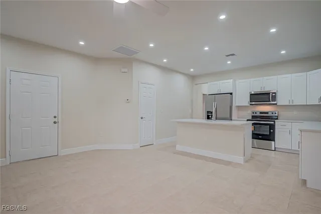 a view of kitchen with windows sink and microwave