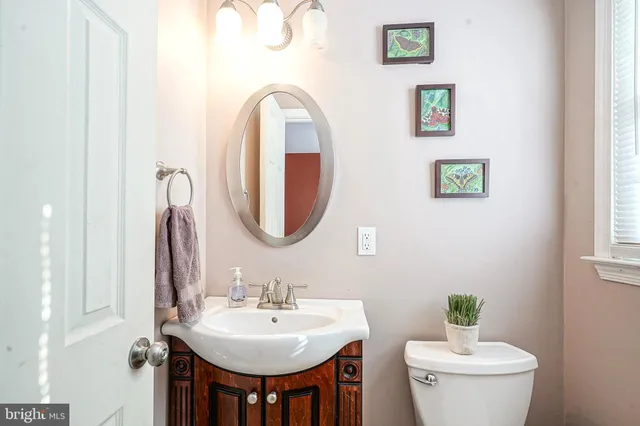 a bathroom with a toilet a sink and a mirror