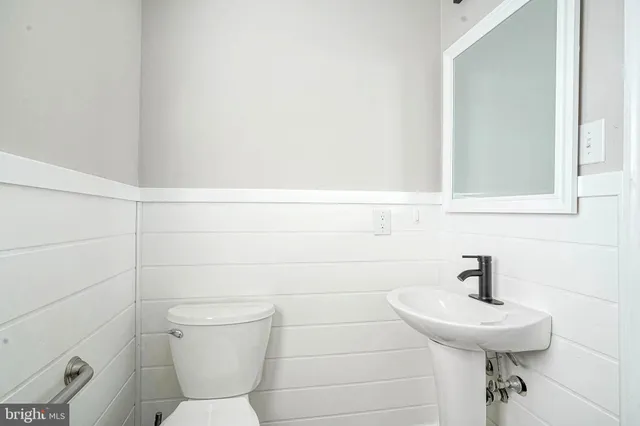 a bathroom with a toilet sink and mirror