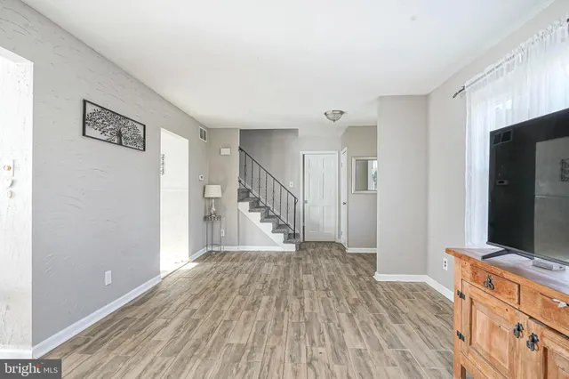 a view of a hallway with wooden floor and staircase