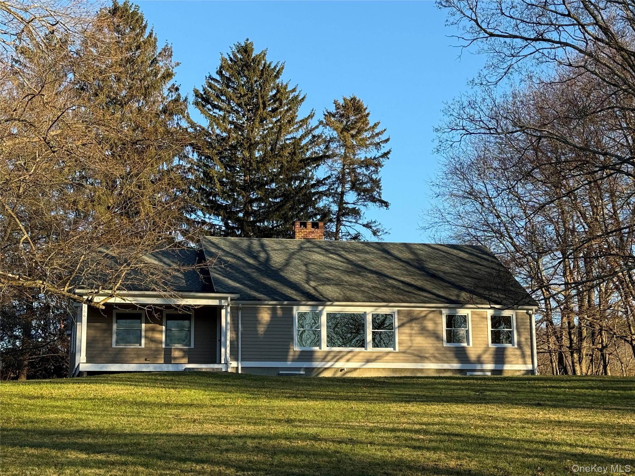156 Sharon Station Road Amenia, NY 12501 - Photo 1 of 17 a front view of a house with a garden and trees