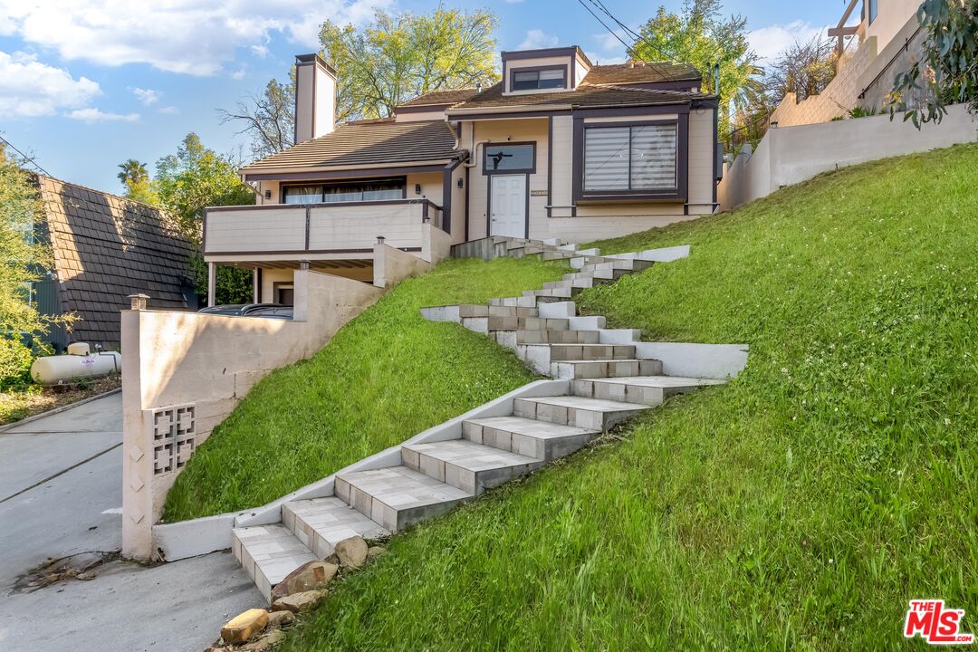 a view of a house with backyard sitting area and garden