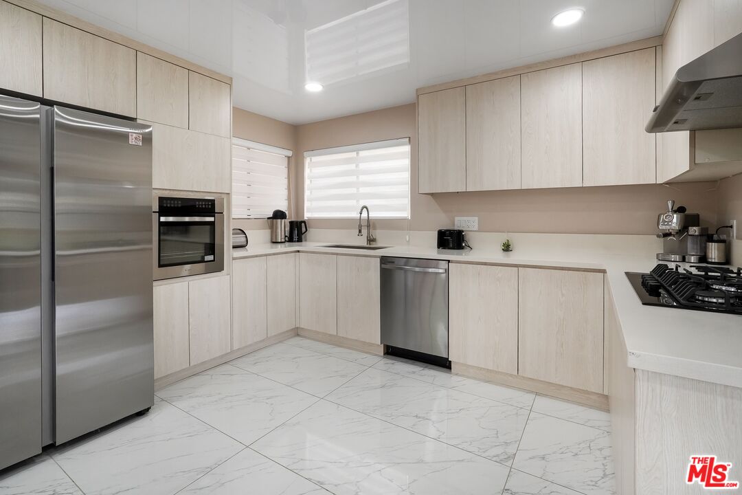 2015 Corral Canyon Road Malibu, CA 90265 - Photo 5 of 24 a kitchen with white cabinets and stainless steel appliances