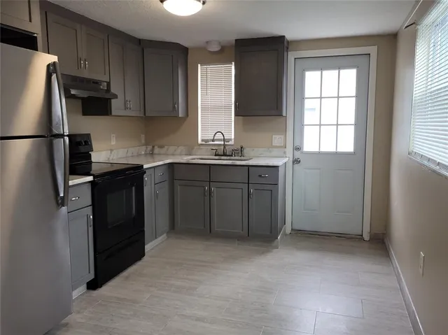 a kitchen with a sink refrigerator and cabinets