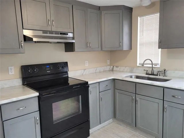 a kitchen with cabinets appliances and a sink