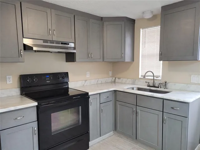 a kitchen with cabinets appliances a sink and a counter