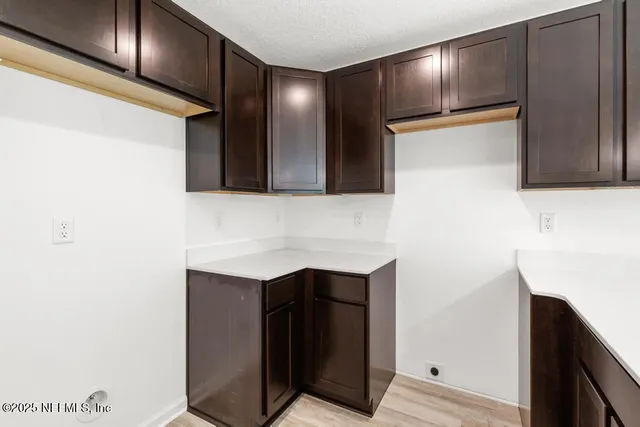 a kitchen with stainless steel appliances kitchen island granite countertop a sink a stove and a wooden floors