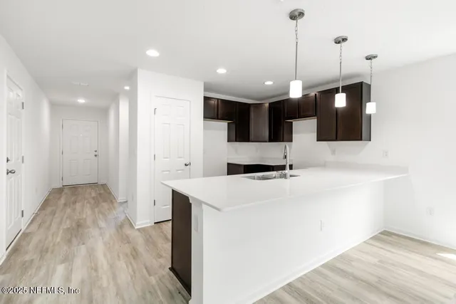 a view of an empty room with wooden floor and a fireplace