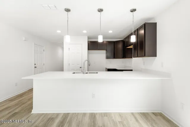 a large white kitchen with a sink a large window and stainless steel appliances