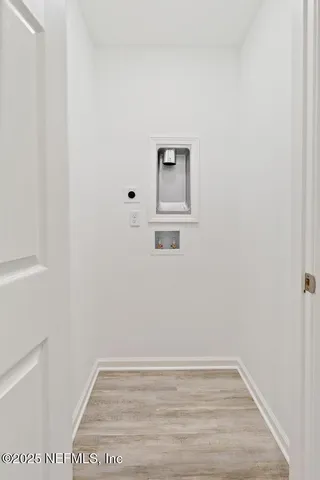 a view of a small space with wooden floor and a window