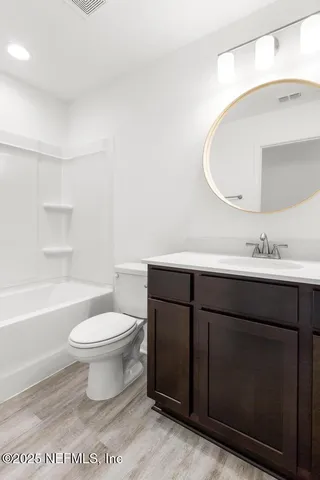 a bathroom with a sink toilet a mirror and vanity