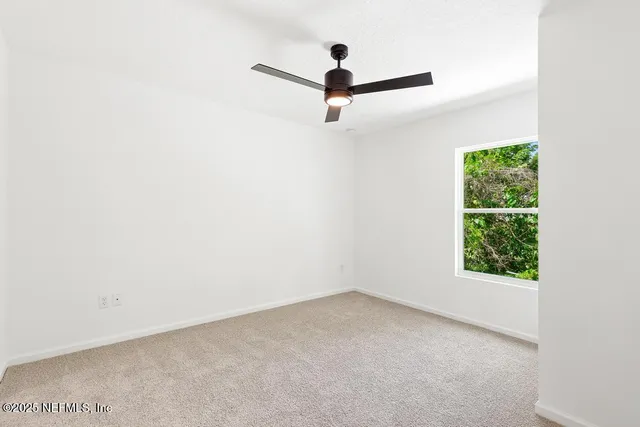 a view of a room with window and ceiling fan