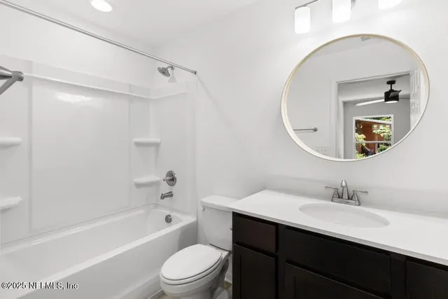 a bathroom with a bathtub shower sink mirror and toilet